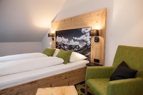 a hotel room with a bed and a chair at Hierlhof in Immenstadt im Allgäu
