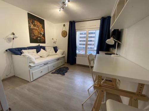 Cette chambre comprend un lit, un bureau et une fenêtre. dans l'établissement Appartement Esplanade, à Strasbourg