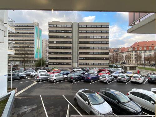 a parking lot with cars parked in front of a building at Appartement Esplanade in Strasbourg