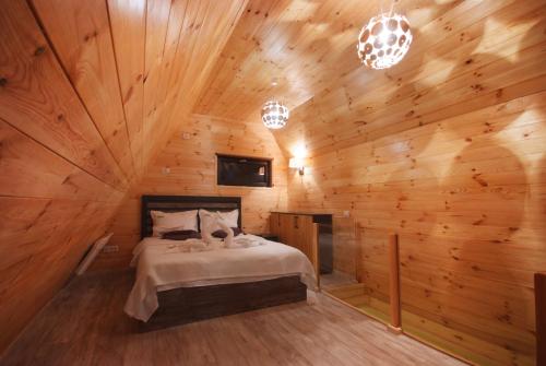 a bedroom with a bed in a wooden cabin at KubiA in Slănic-Moldova