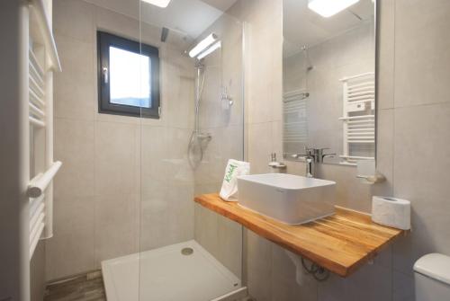 a white bathroom with a sink and a shower at KubiA in Slănic-Moldova