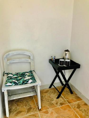 a white chair sitting next to a side table at CapitalT Luxury Guest House in Germiston