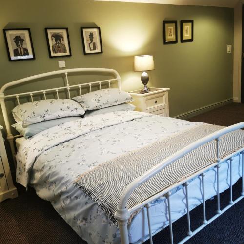 a bedroom with a white bed with pillows on it at Rooms by the River at Glan Aber in Cynwyd