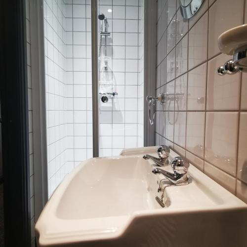 a bathroom with a white sink and a mirror at Rooms by the River at Glan Aber in Cynwyd