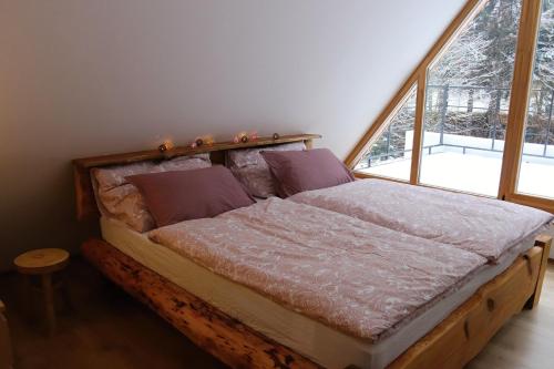a bed in a room with a large window at Pod Beskydem, Velké Karlovice in Velké Karlovice