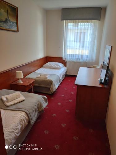 a hotel room with two beds and a desk at Panorama_SPA in Trzęsacz