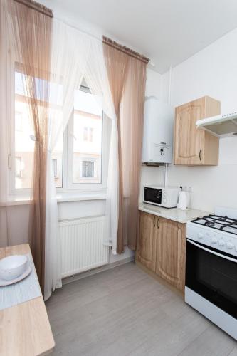 a small kitchen with a window and a stove at Центр. Хмельницького 6а. 2 кімнати. in Ternopilʼ