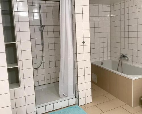 ein Badezimmer mit einer Dusche, einer Badewanne und einem Waschbecken in der Unterkunft Krone in Dolgesheim