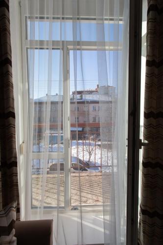 a window with a view of a building at Центр. Хмельницького 6а. 2 кімнати. in Ternopilʼ