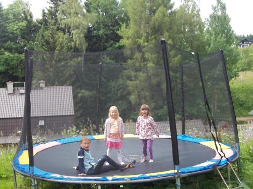 three children playing on a trampoline at Pension Familia in Harrachov