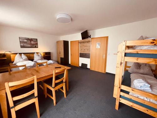 a room with a table and a bed and bunk beds at Haus Heimat Wagrain in Wagrain