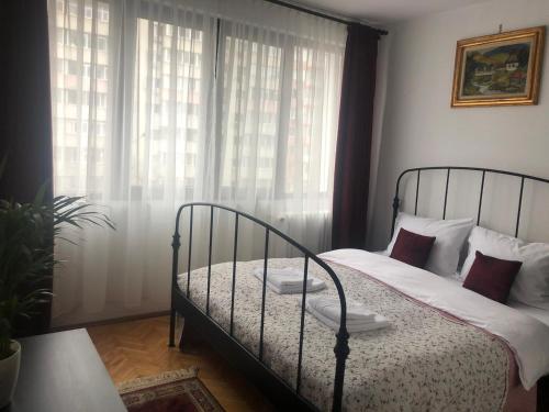 a bedroom with a bed and a window with curtains at Marie Apartment in Bucharest