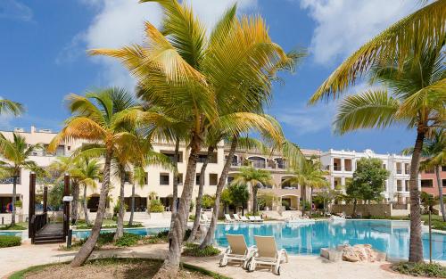 un complejo con palmeras y piscina en Luxe 1 BR Cap Cana, DR - Steps Away From Pool, King Bed, Caribbean Paradise! en Punta Cana