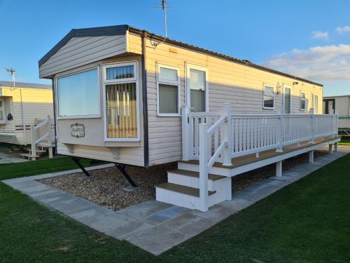 a tiny house with a porch and a staircase at 6 Berth Central heated on The Chase (Balmoral) in Ingoldmells