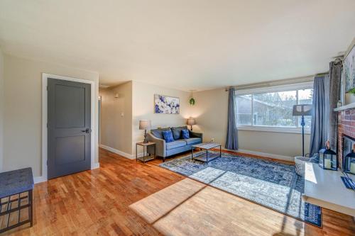 sala de estar con sofá azul y ventana en Renton Oasis- Relaxing 3BR Home with Great Outdoor! home, en Renton