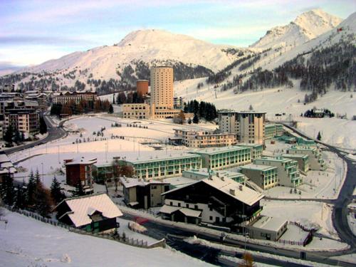 a city with snow on the ground and buildings at Villaggio Olimpico in Sestriere