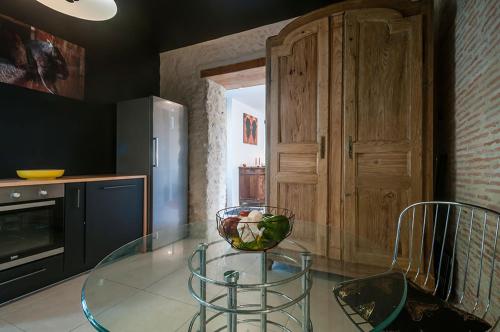 - une table en verre dans la cuisine avec un bol dans l'établissement Villa Courreau - Maison de maitre, à Vendays-Montalivet