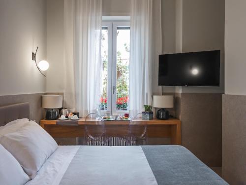 a bedroom with a bed and a desk with a television at Maison boutique Matteotti in Matera
