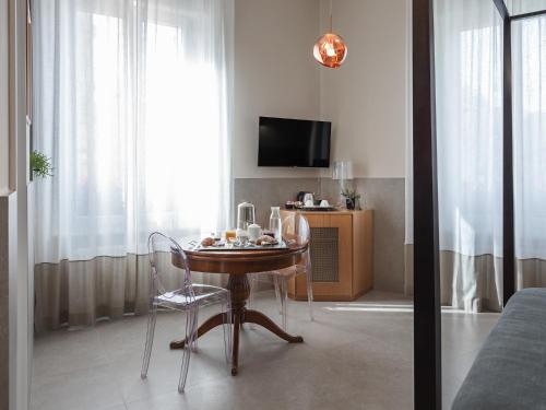 a room with a table with a chair and a tv at Maison boutique Matteotti in Matera