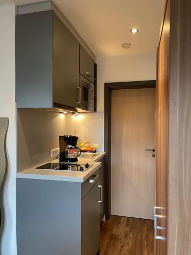 a small kitchen with a stove and a door at City-Apparte ONE Zentrales & komfortables Wohnen in Gronau in Gronau
