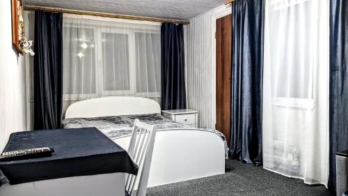 - une chambre avec un lit blanc, une table et des fenêtres dans l'établissement садиба Сніжок, à Yaremtche