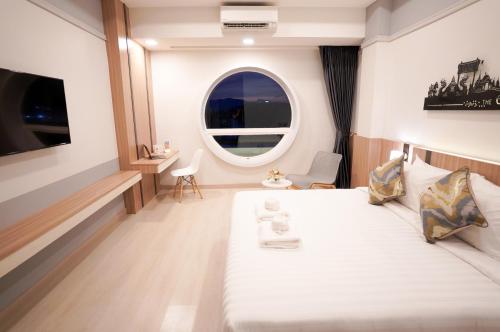 a bedroom with a large white bed and a window at The Space Hotel Chiang Rai in Chiang Rai