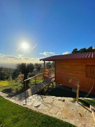 a wooden building with a staircase next to a field at Quinta Altamira in Portalegre