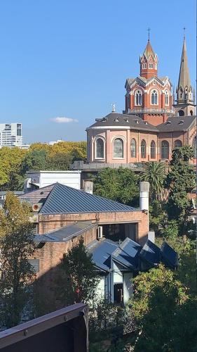 un gran edificio de ladrillo con una iglesia en el fondo en Cañitas 3amb cochera fija techada solo CON RESERVA en Buenos Aires
