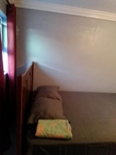 Bett in einem Zimmer mit einer Wand in der Unterkunft Errol and Nancy's Place in Nassau