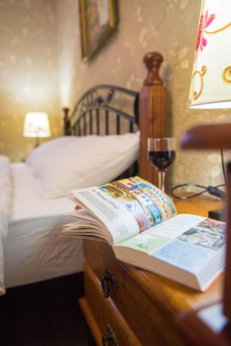 a desk with a book and a glass of wine at Terrace House Near Opera in Tbilisi City