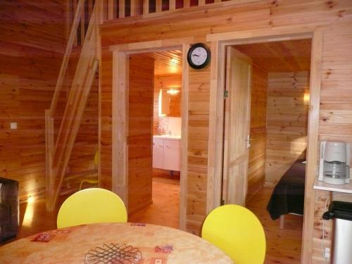 a room with yellow chairs and a clock on the wall at Les gîtes des Palombes in Fronton