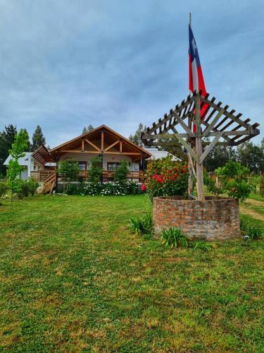 a house with a american flag in a yard at Mauleuvu Outdoor, alojamiento bed and breakfast y actividades outdoor in Talca