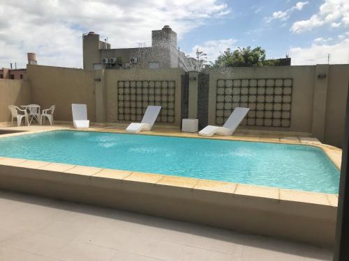 a swimming pool with lounge chairs on a roof at DON Hotel CHIVILCOY in Chivilcoy