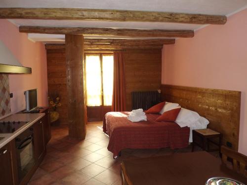 a bedroom with a bed and a kitchen with a window at Residence Du Commerce in Oulx