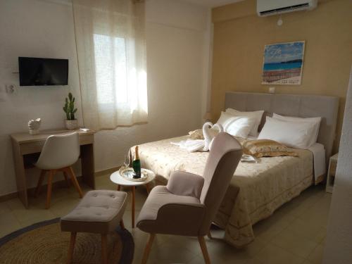 a bedroom with a bed with a chair and a table at Secret Paradise in Koutsounari