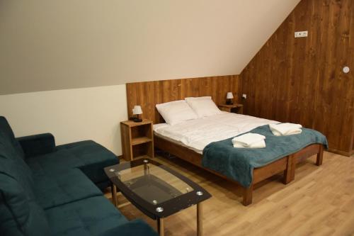 1 dormitorio con cama, sofá y mesa de cristal en Apartament CEKO, en Ostrowsko