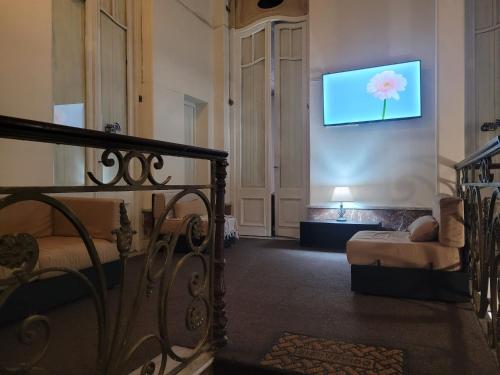 een woonkamer met een televisie aan de muur bij Hotel Ateneo in Montevideo