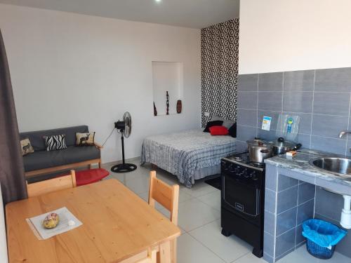 Guest House Maio في فيلا دو مايو: مطبخ وغرفة معيشة مع طاولة وأريكة