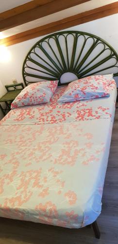 - un lit avec une couette à fleurs et 2 oreillers dans l'établissement Villa Naturiste NATURE Héliovillage 104, au Cap d'Agde