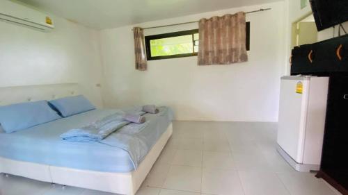 a white room with a bed and a window at Moon River Resort Phimai in Phimai