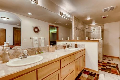 baño con 2 lavabos y espejo grande en Los Pinos - Luxury Breckenridge SkiCondo, en Breckenridge