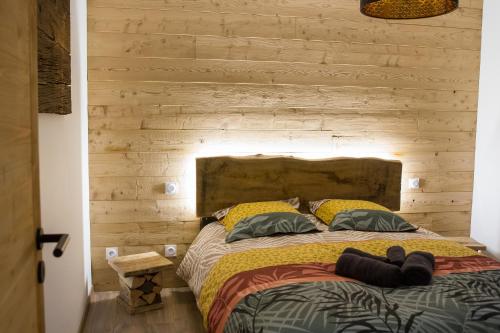 a bed in a room with a wooden wall at Chalet de standing 9P avec sauna & salle d'escalade in La Bresse