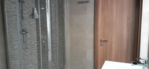 een badkamer met een douche en een glazen deur bij Sayonara in Marsaxlokk