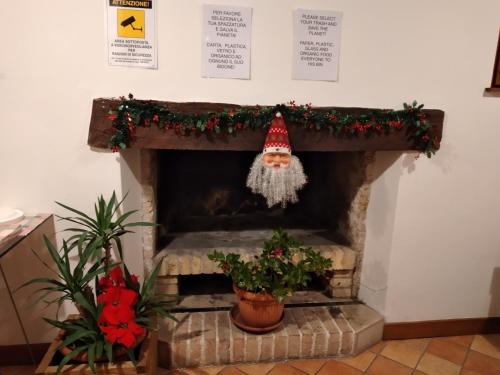 a fireplace with a santa hat and christmas decorations at Ostello Europa in San Vito al Tagliamento