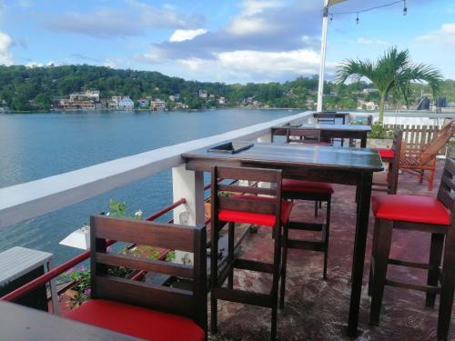 a row of tables and chairs with a view of the water at Hotel La Union in Flores