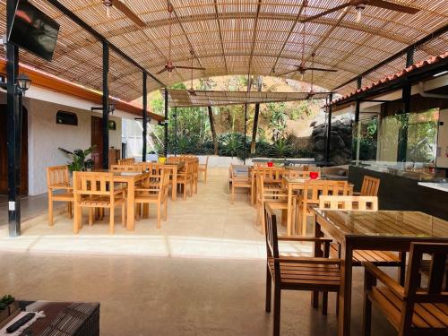 a restaurant with wooden tables and wooden chairs at Hotel Ocotal Bed & Breakfast in Ocotal