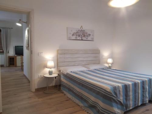 a bedroom with a bed with a striped blanket and two lamps at La casa di Primo in Montecosaro