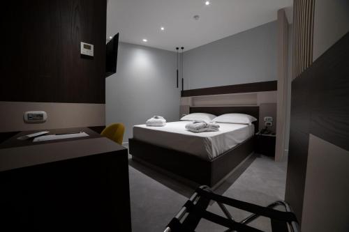 a bedroom with a bed and a desk with a chair at Marconi Hotel in Rende