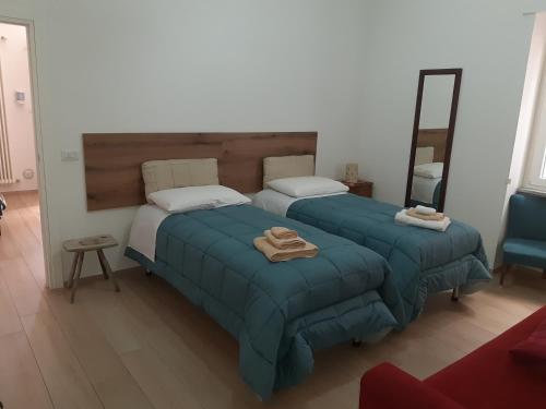 1 dormitorio con 2 camas y espejo en Casa vacanze Nonna Lucia, en Matera