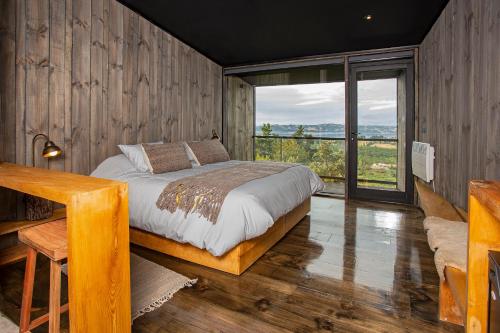 a bedroom with a bed and a large window at Hotel & Cava Estancia Rilán in Castro